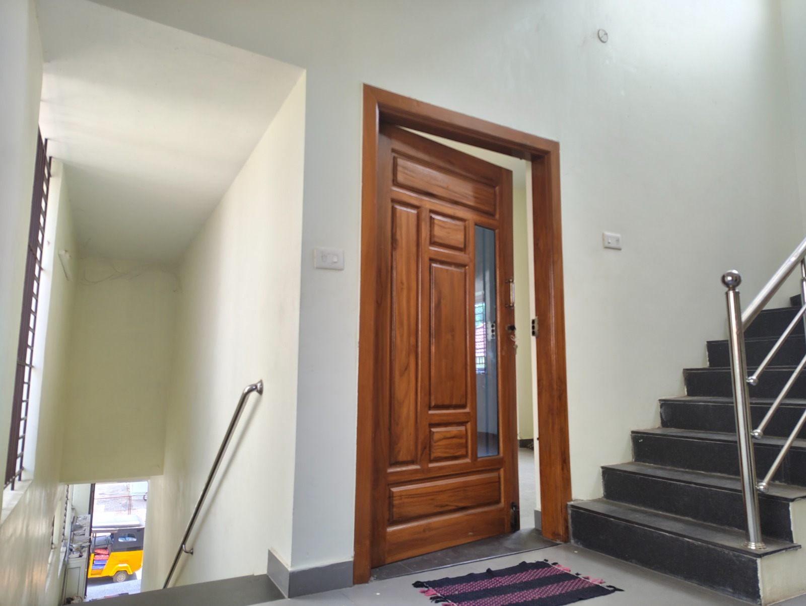 Entrance stairwell with granite steps, steel railing and teak wood door